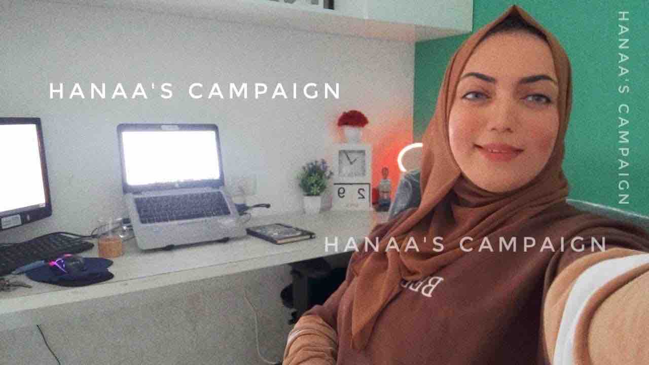 Hana Al-Lulu posing at her desk in front of the computer in her office, where she worked as a graphic designer before the war.